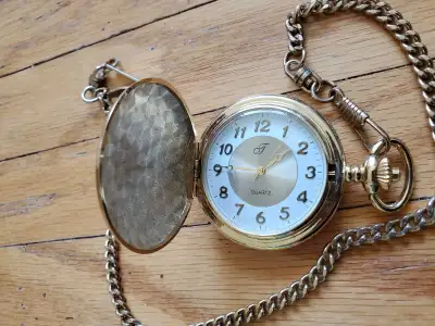 I am selling a used pocket watch. The watch has a gold finish and comes with a chain. The front and...