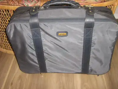 Canvas material grey, medium size suitcase size 17"x24"x7" on wheels. The brand is Holiday