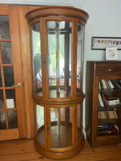 Vitrine en demi-lune avec fond en miroir qui donne un effet de rondeur. Éclairage encastré. Ce meubl...