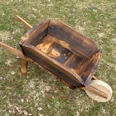 This charming wooden wheelbarrow planter is perfect for adding a rustic touch to your garden or pati...