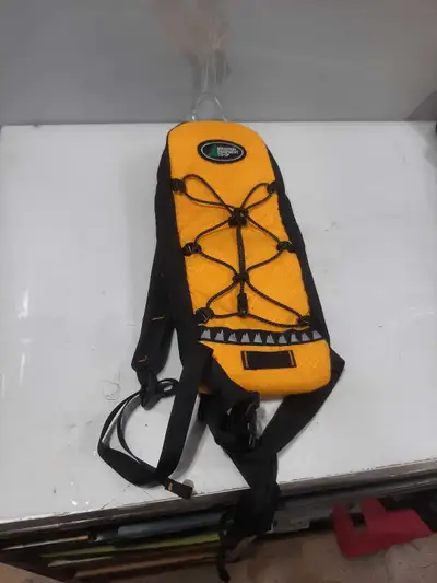 This is a Mountain Equipment Co-op yellow hydration pack, perfect for outdoor activities. It's in go...