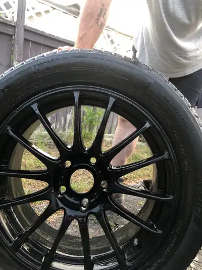 I am selling a set of four pre-owned Michelin winter tires mounted on sleek, black aftermarket alloy...