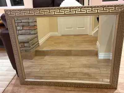 Decorative mirror with antique brass/gold-toned frame., View more