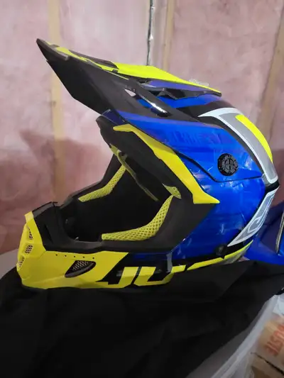 Get ready to ride with this eye-catching racing motocross helmet, designed with a vibrant blue and y...