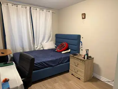 This bedroom includes a bed, side table, chair and curtains. It is perfect for an individual looking...