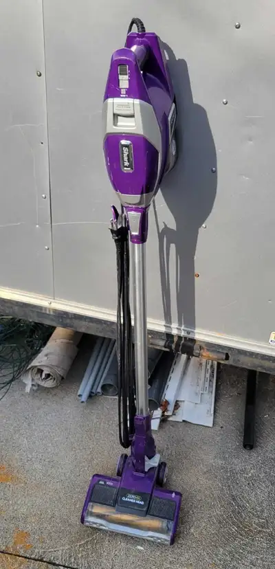 Powerful corded stick vacuum is a purple Shark Rocket model. It has a Zero-M cleaner head designed f...