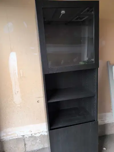 This is a used IKEA Billy Bookcase with Glass Door in Black-Brown finish, offering a stylish storage...