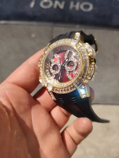 I am selling this eye-catching, pre-owned men's iced-out homage watch featuring a vibrant red face a...