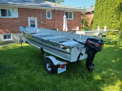 14 ft Starcraft aluminum fishing boat. 15 hp Mercury 2 stroke outboard motor. And matching Northtrai...