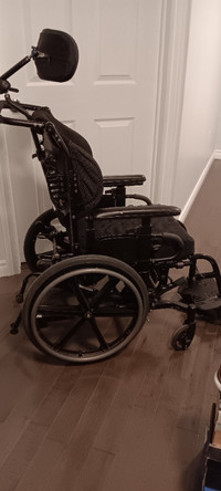 Tilting wheelchair with headrest