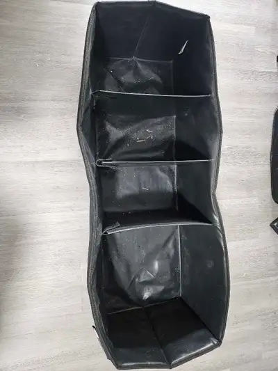 This black cargo organizer has multiple compartments. It folds flat for storage when not in use. It'...