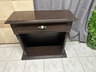 Classic dark‑wood nightstand with a smooth finish, decorative side columns, and a sturdy build. Feat...