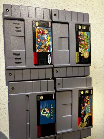 I am selling a collection of four classic Super Nintendo Entertainment System (SNES) game cartridges...