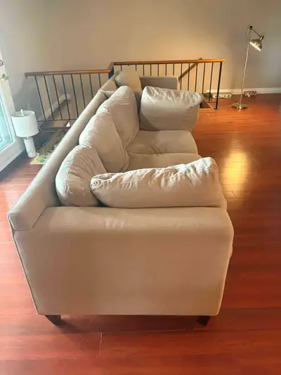 This is a used couch with a neutral colour and comfortable cushions, ideal for a living room. The ph...