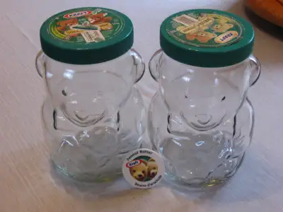 Two vintage, Kraft peanut butter coin jars. No cracks or chips on the heavy glass. Coin slot tops. 1...
