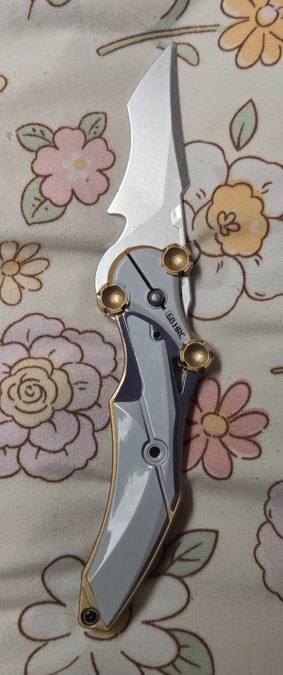 This eye-catching pair of collectible knives includes a uniquely shaped folding knife and a golden b...