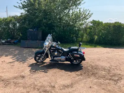 This is a Harley-Davidson Road King, known for its comfortable ride and classic styling. It is a use...
