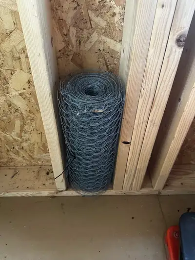 This is a large, slightly unrolled roll of chicken wire, perfect for various fencing or crafting pro...