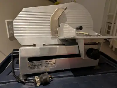 A commercial meat slicer, vintage model manufactured by C.EL.ME. made in Italy. It features a 2-phas...