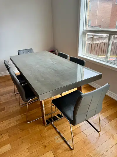 This modern dining set features a sleek, grey wood-look top and stylish chrome legs, offering a cont...