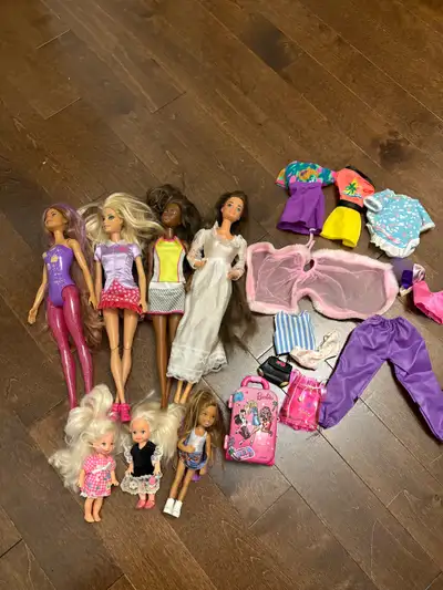 This lot includes several used Barbie dolls with various outfits and accessories, ready for a new ho...
