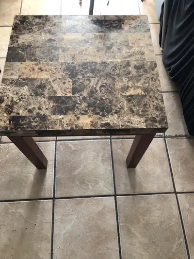 This is a used end table with a faux marble top, perfect for adding a touch of elegance to any room....