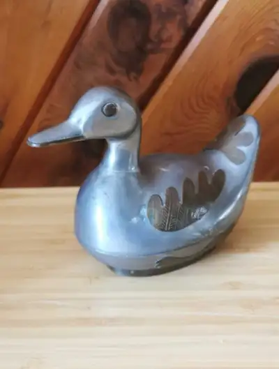 Beautiful vintage pewter duck trinket box accented with ornate brass details and raised on a decorat...