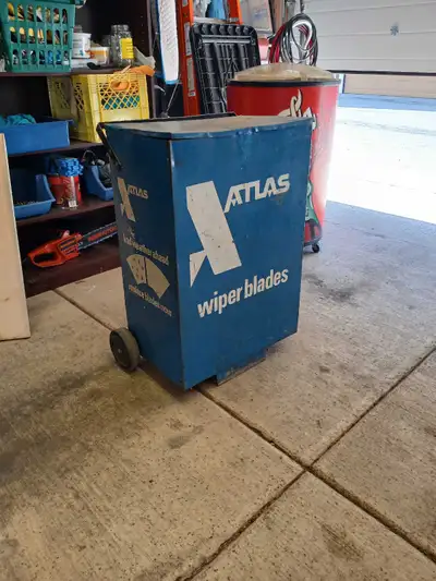 This is a vintage Atlas Wiper Blades metal storage bin on wheels, perfect for adding a touch of retr...