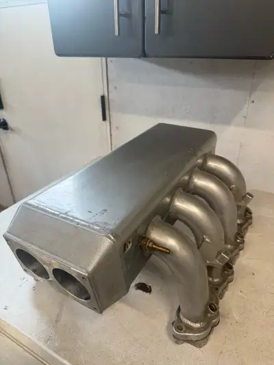 Upgrade your engine's performance with this custom-fabricated aluminum intake manifold designed for...