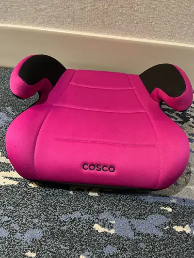 This is a Cosco pink booster seat with black armrests that is in good condition. It's ready to help...