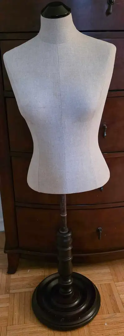 This is a beige linen dress form mannequin with a dark wooden tripod base. Pick up Dawes Road and Da...