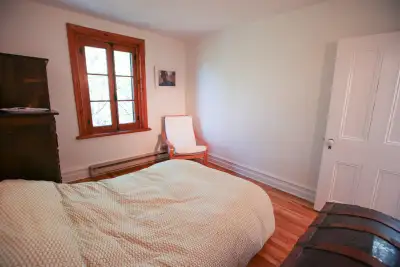 Chambre lumineuse, propre et meublée d’un lit king avec literie et d’une commode, dans un appartemen...