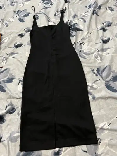 This is Aritzia dress with a sleek black design and a flattering midi length, perfect for a night ou...