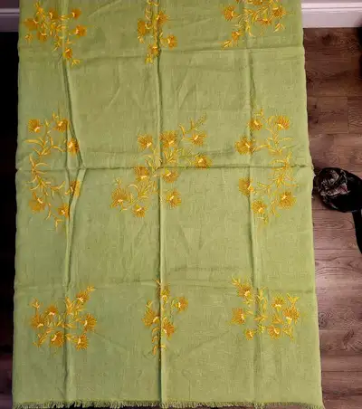 Green linen tablecloth featuring  floral machine embroidery, View more
