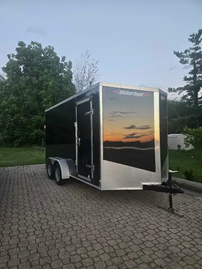 This black Weberlane enclosed cargo trailer features a reliable tandem axle configuration, a conveni...
