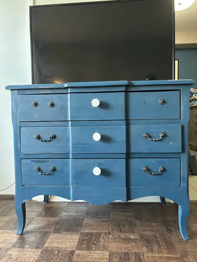 Here's a charming wood dresser with a unique blue colour. It features multiple drawers, perfect for...