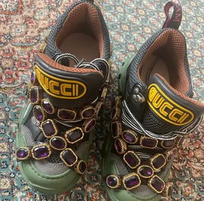 These Gucci Flashtrek sneakers feature a bold, avant-garde design with removable crystal straps, cra...