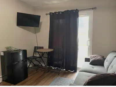Private Room rental with a private entrance which includes a small fridge, bed, couch and clothing r...