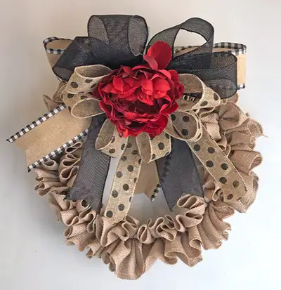 This simple black and beige burlap wreath has a dark red peony to make it pop. The thick burlap ribb...
