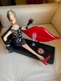 Reclining smoking lady on a red lip and black bench