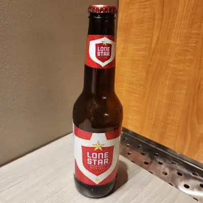 12 ounce Lone Star beer bottle with cap. Brewed in Fort Worth, Texas. Empty, bottle and labels in ex...
