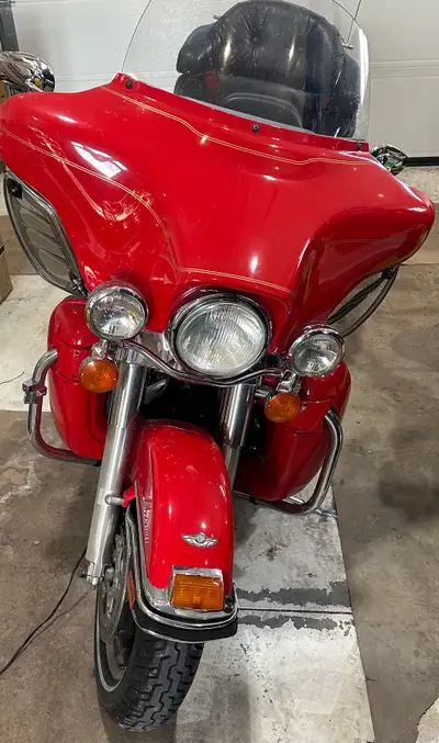 Get ready for the open road with this classic, red Harley-Davidson Electra Glide touring motorcycle....