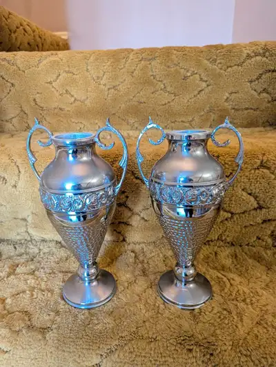 These elegant matching metal urn vases feature a classic twin-handled design with an intricate flora...