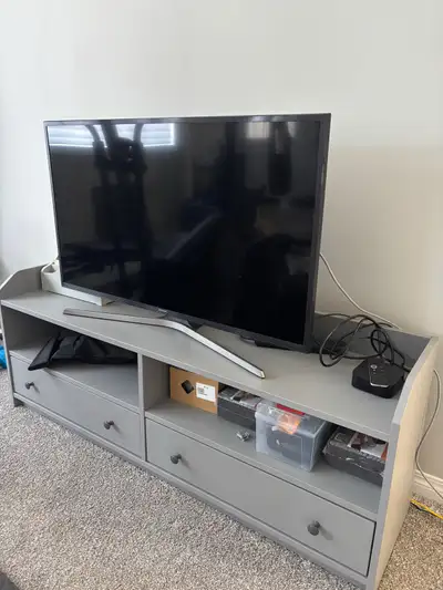This grey TV stand has drawers and shelving space. It's designed to hold a 55-inch TV. Perfect for o...