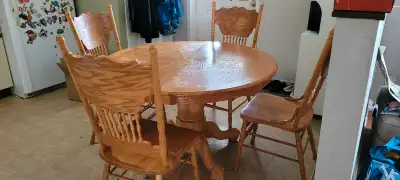 Oak Table and Chairs w/Matching Hutch. Table measures 72" w/leaf in, 48" round w/o leaf in. Table an...