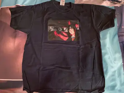 A black T-shirt of Itachi Uchiha from Naruto. The base shirt is from Fruit of the Loom, and the grap...