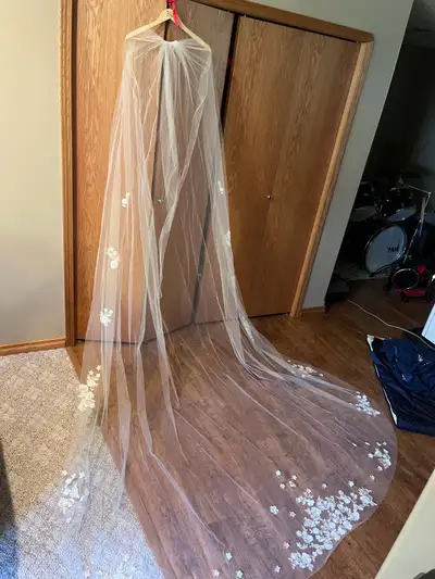 This is a long, flowing wedding veil with beautiful floral embroidery. It is made from soft, sheer t...