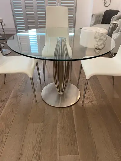 Contemporary pedestal dining table with 12mm clear tempered glass top and brushed round stainless st...