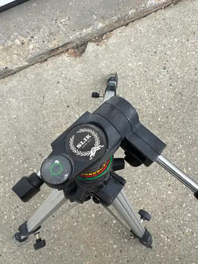 This is a used Slik tripod, perfect for photographers or videographers needing a stable support syst...
