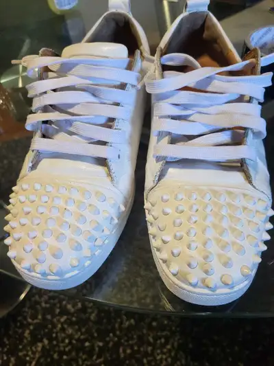 Step out in style with these striking Christian Louboutin white leather sneakers, complete with dist...